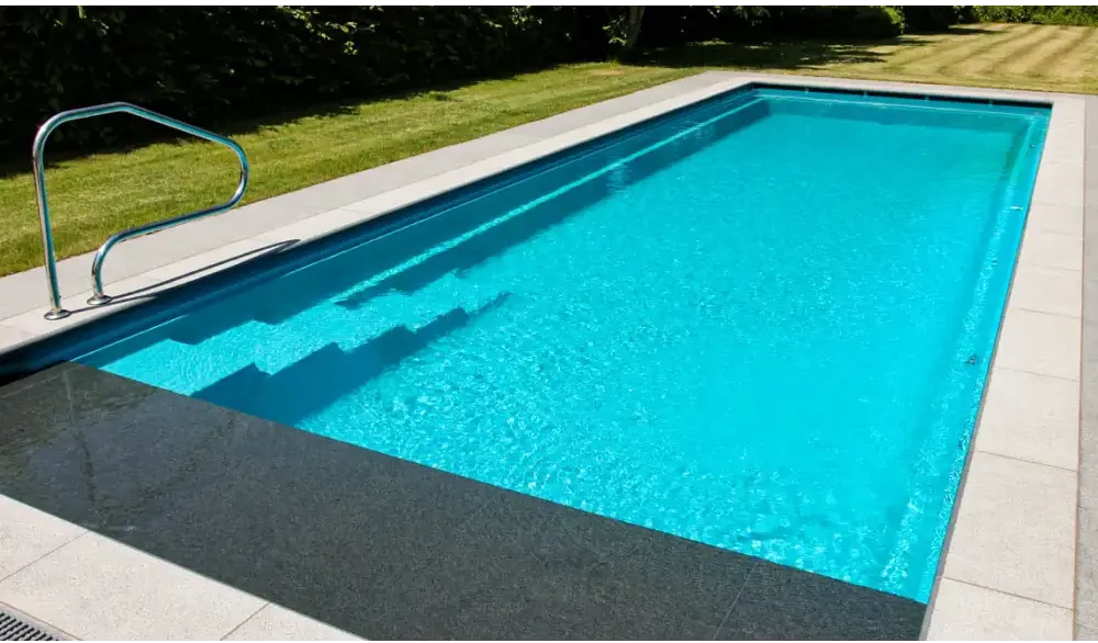 Modern Leisurepools Cube utomhuspool med turkost vatten och metallräcke